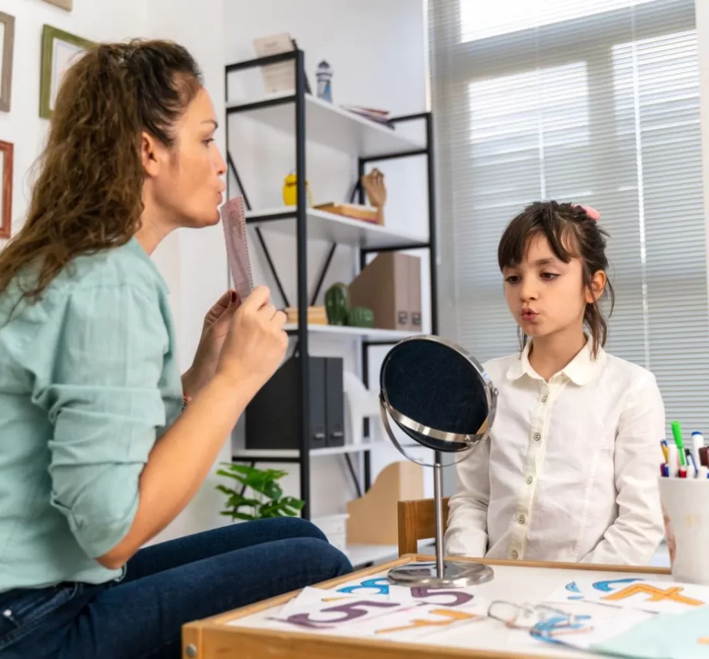 Woman teaching a girl on speech and mouth movements