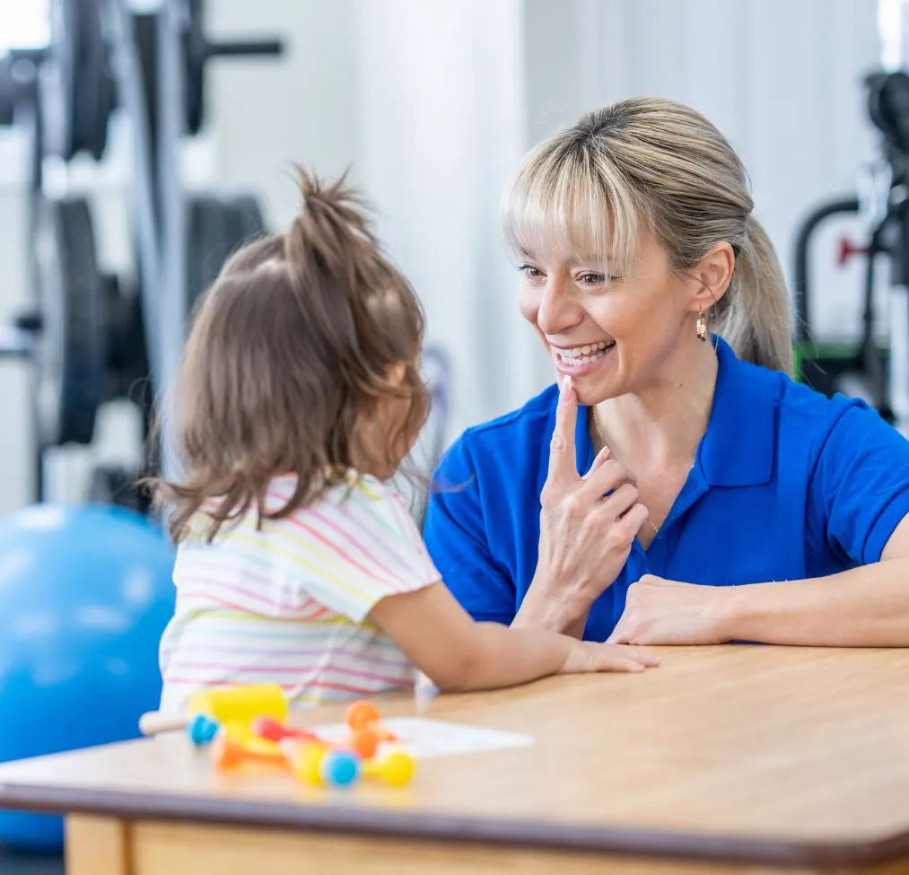 Woman wearing blue shirt talking to a little girl