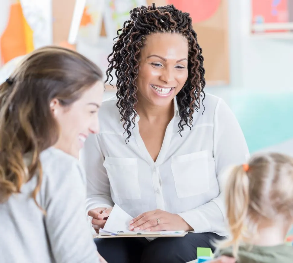 Mother and daughter talking to her teacher